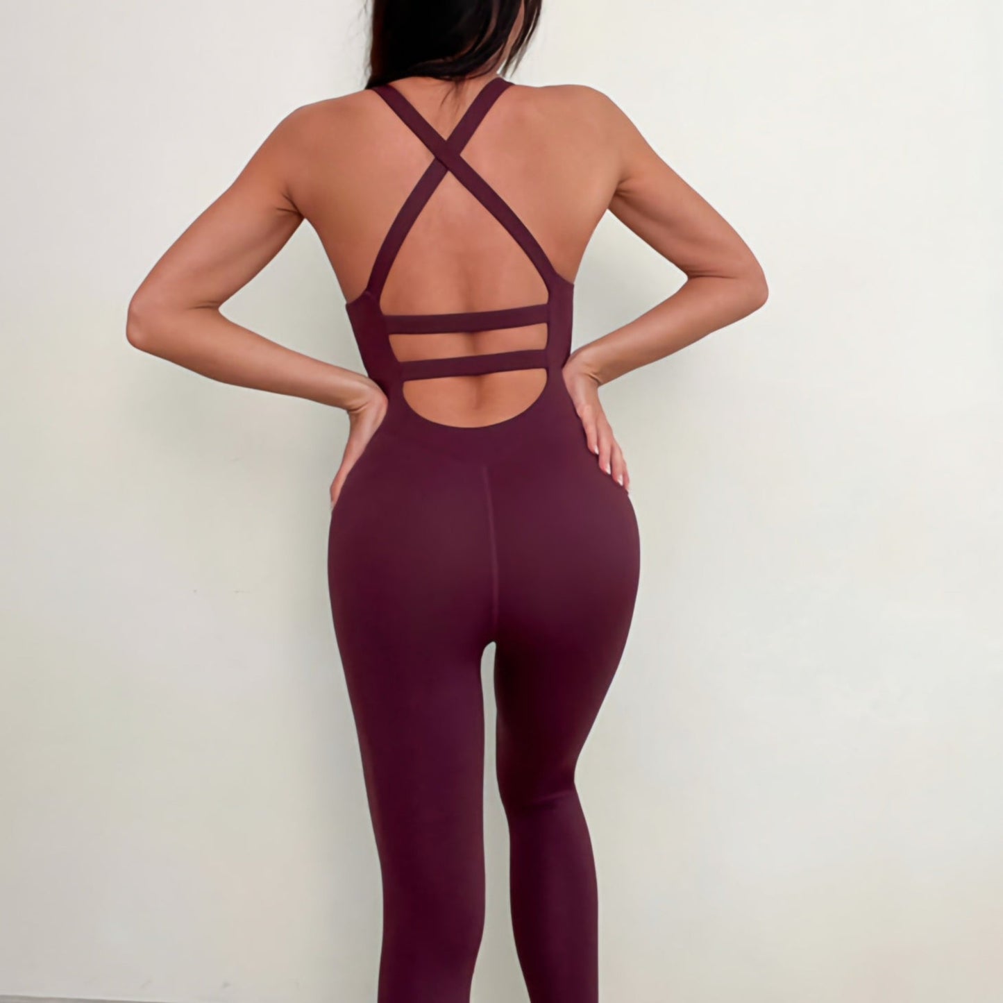 Back photograph of fitness model showcasing a sexy and contouring workout jumpsuit in the colour burgundy from Vibras Activewear.