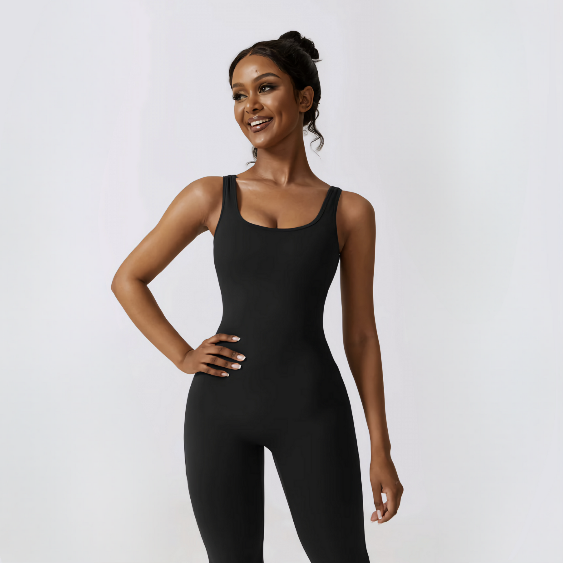 Fitness model smilling, wearing the cute and sexy Samara jumpsuit  in black from Vibras Activewear.