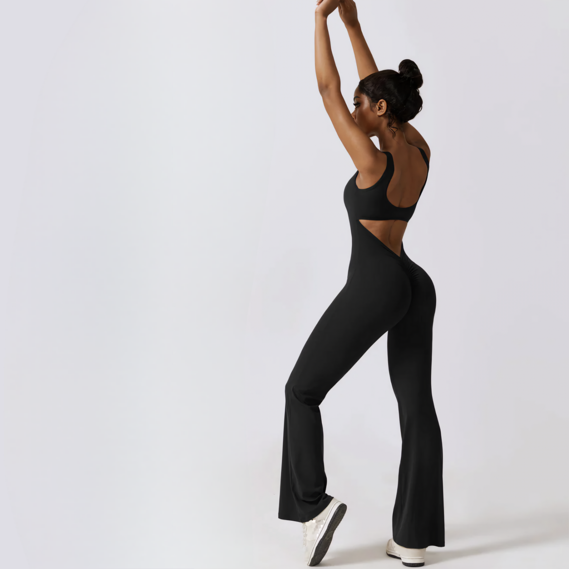 Fitness model wearing a black, open back, ruched bum, wide leg workout jumpsuit from Vibras Activewear.