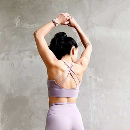 Back view of a fitness model wearing a dusty pink matching workout set from Vibras Activewear.