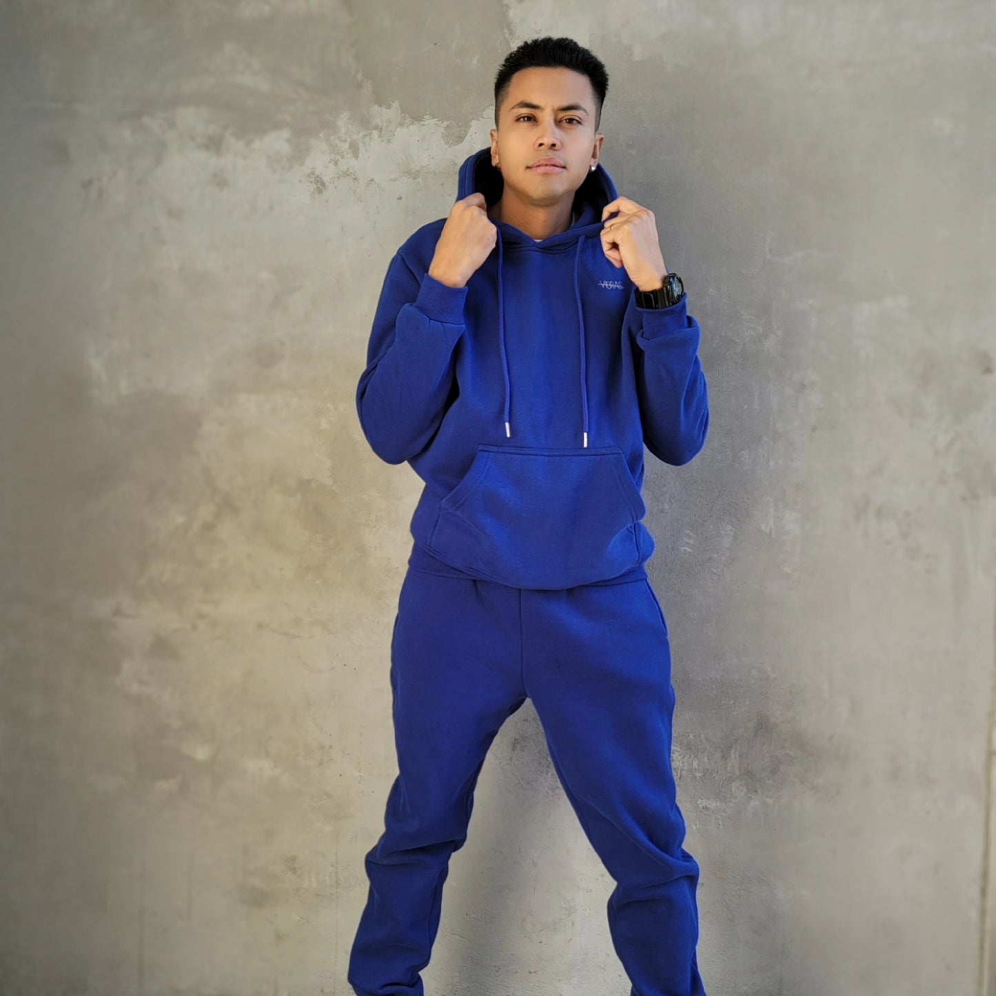 fitness male model wearing a vibrant blue, unisex matching tracksuit from Vibras Activewear.