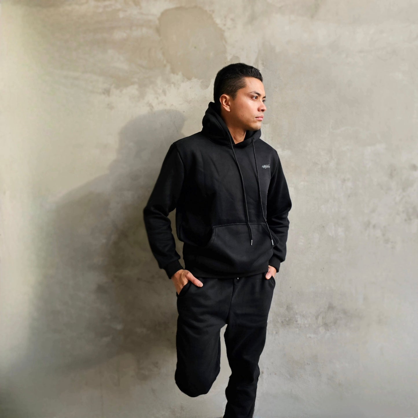 Male model wearing a  black unisex tracksuit from Vibras Activewear.