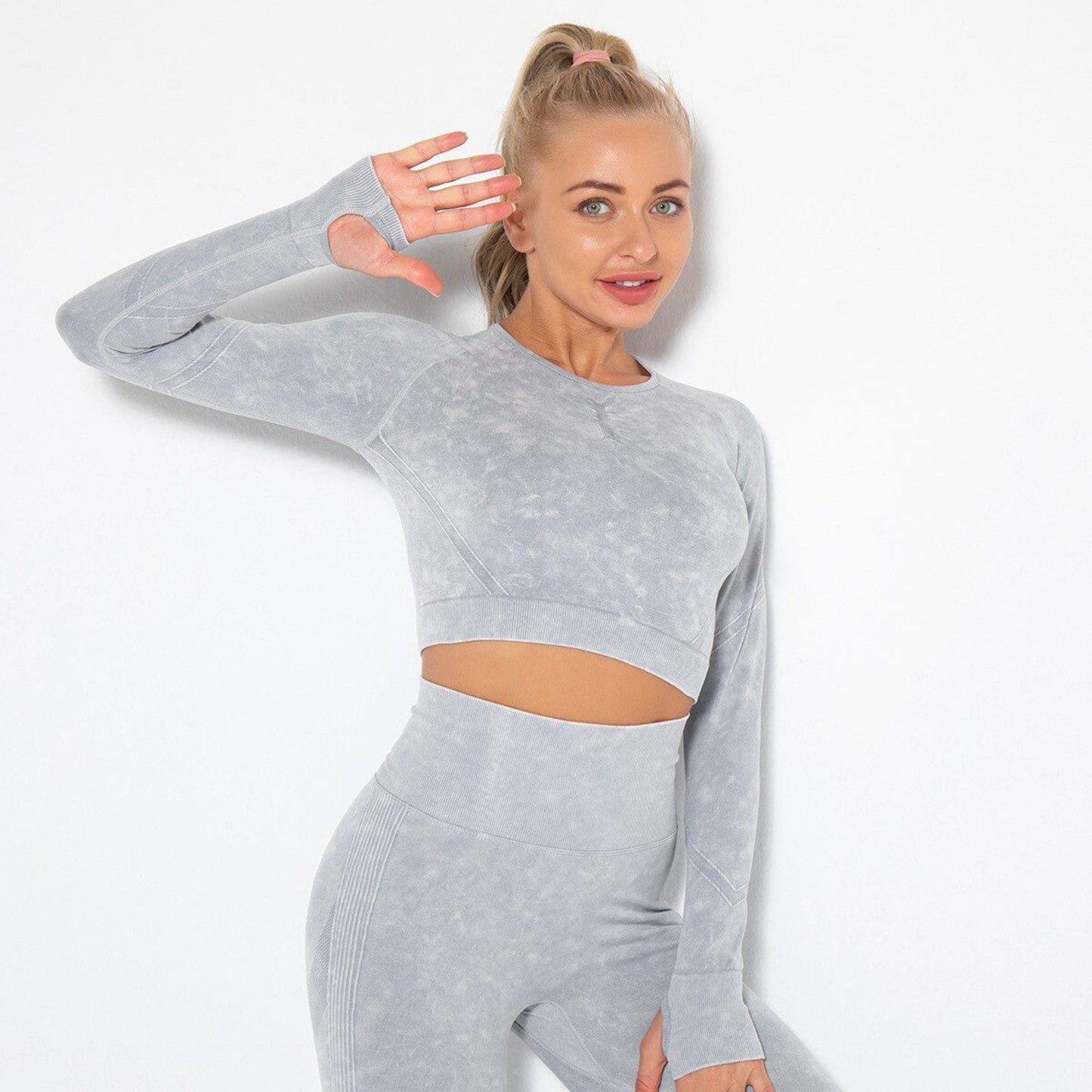FITNESS MODEL STRETCHING IN ARIA WORKOUT CROP TOP  IN GREY  FEATURING THUMBHOLES ON SLEEVES, FROM VIBRAS ACTIVEWEAR.