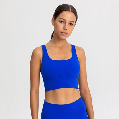 Caucasian woman wearing a bright blue sports bra in photoshoot.