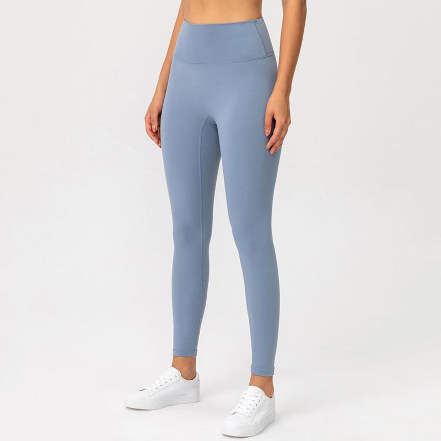 AZURE BLUE, HIGH RISE AND SQUAT PROOF LEGGINGS WORN BY MODEL ON A WHITE BACKGROUND