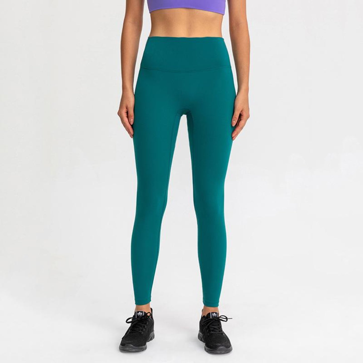 OCEAN GREEN, HIGH RISE AND SQUAT PROOF LEGGINGS WORN BY MODEL ON A WHITE BACKGROUND