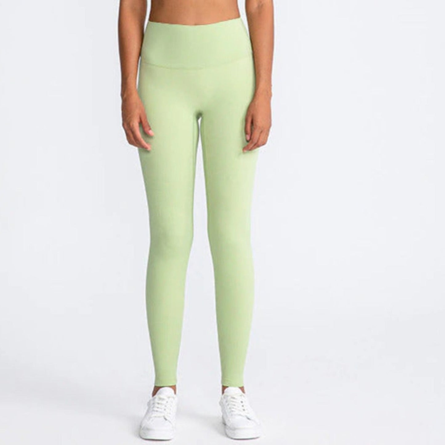 PISTACHIO COLOURED, HIGH RISE AND SQUAT PROOF LEGGINGS WORN BY MODEL ON A WHITE BACKGROUND