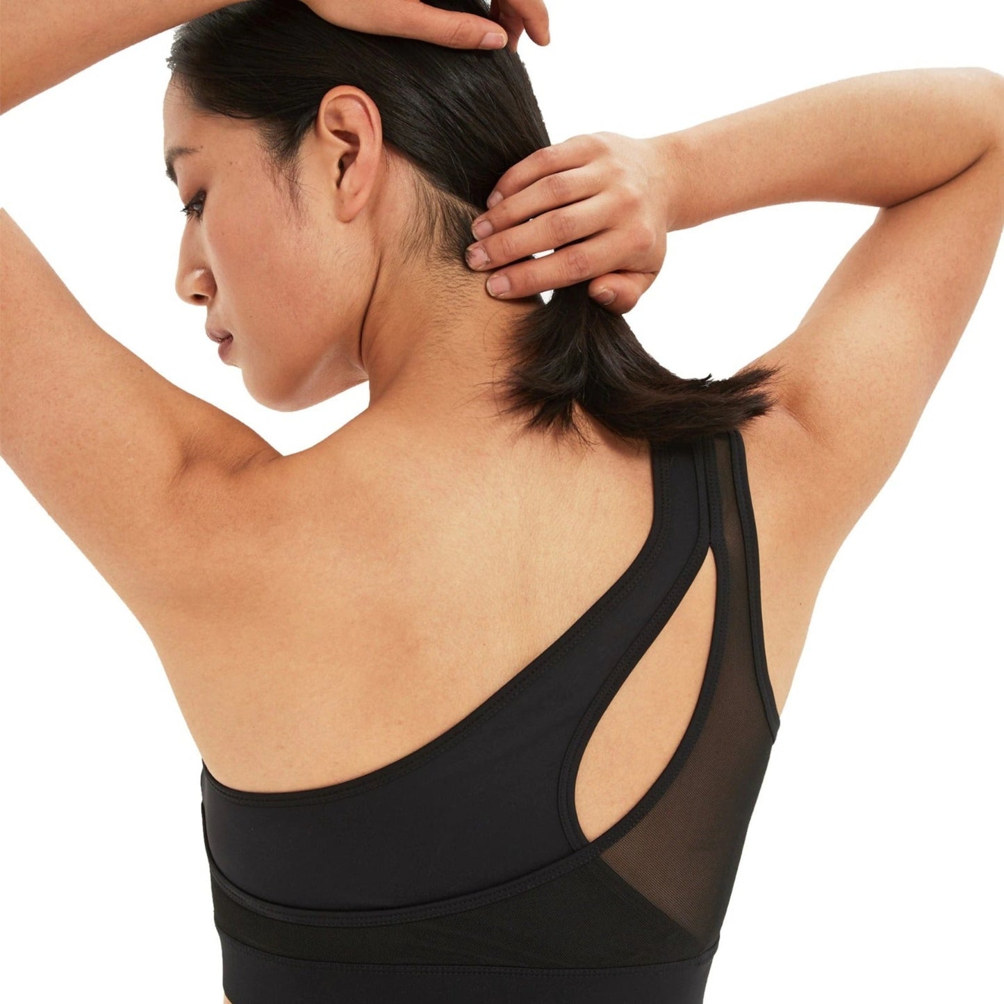 BACK SHOT OF FITNESS MODEL WEARING A ONE SHOULDER, PEEK-A-BOO NECKLINE, BLACK, HIGH IMPACT SPORTS BRA FROM VIBRAS ACTIVEWEAR.